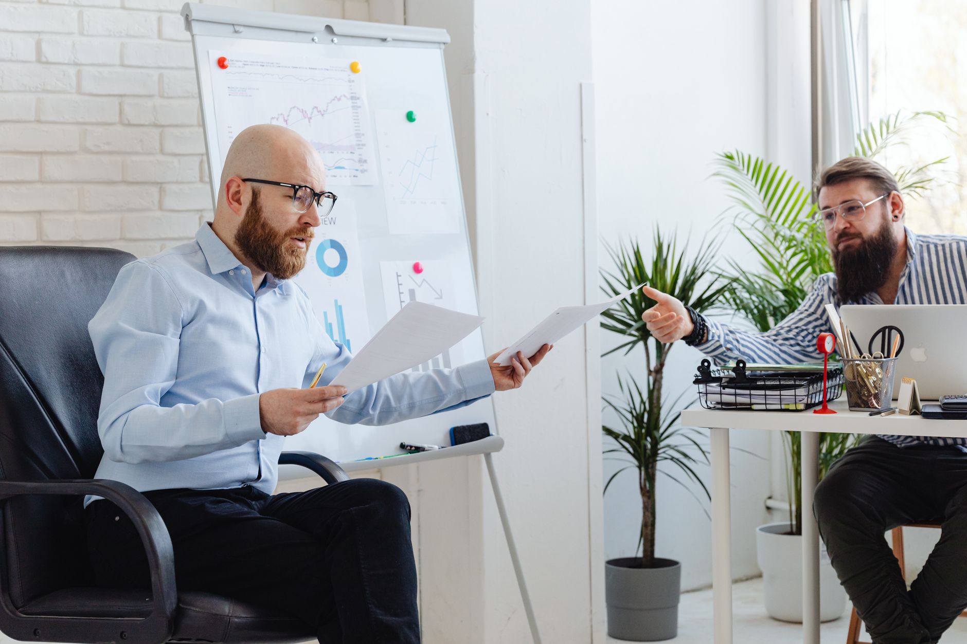 Consultant presenting CRM data to executive team in a boardroom