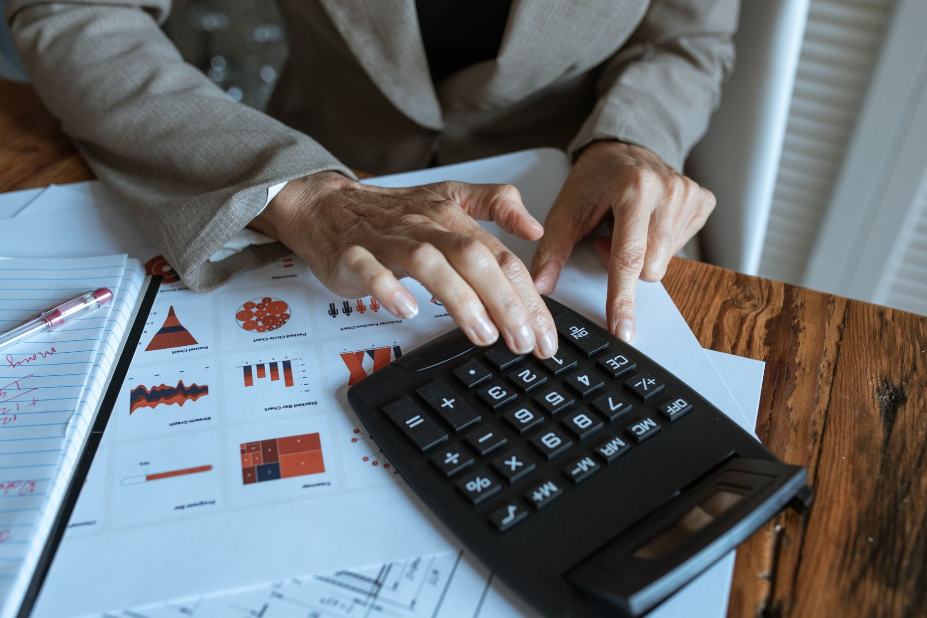 Business owner reviewing CRM budget and pricing on a laptop with calculator