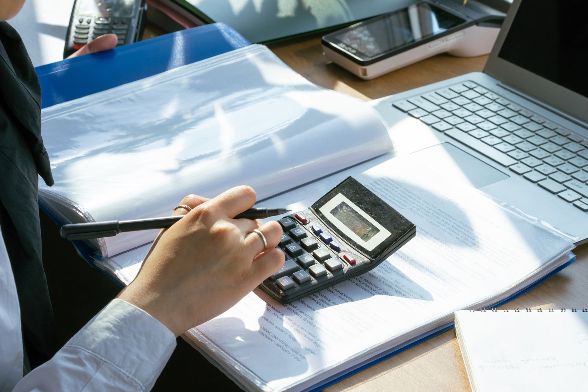 Business owner reviewing CRM budget and pricing on a laptop with calculator