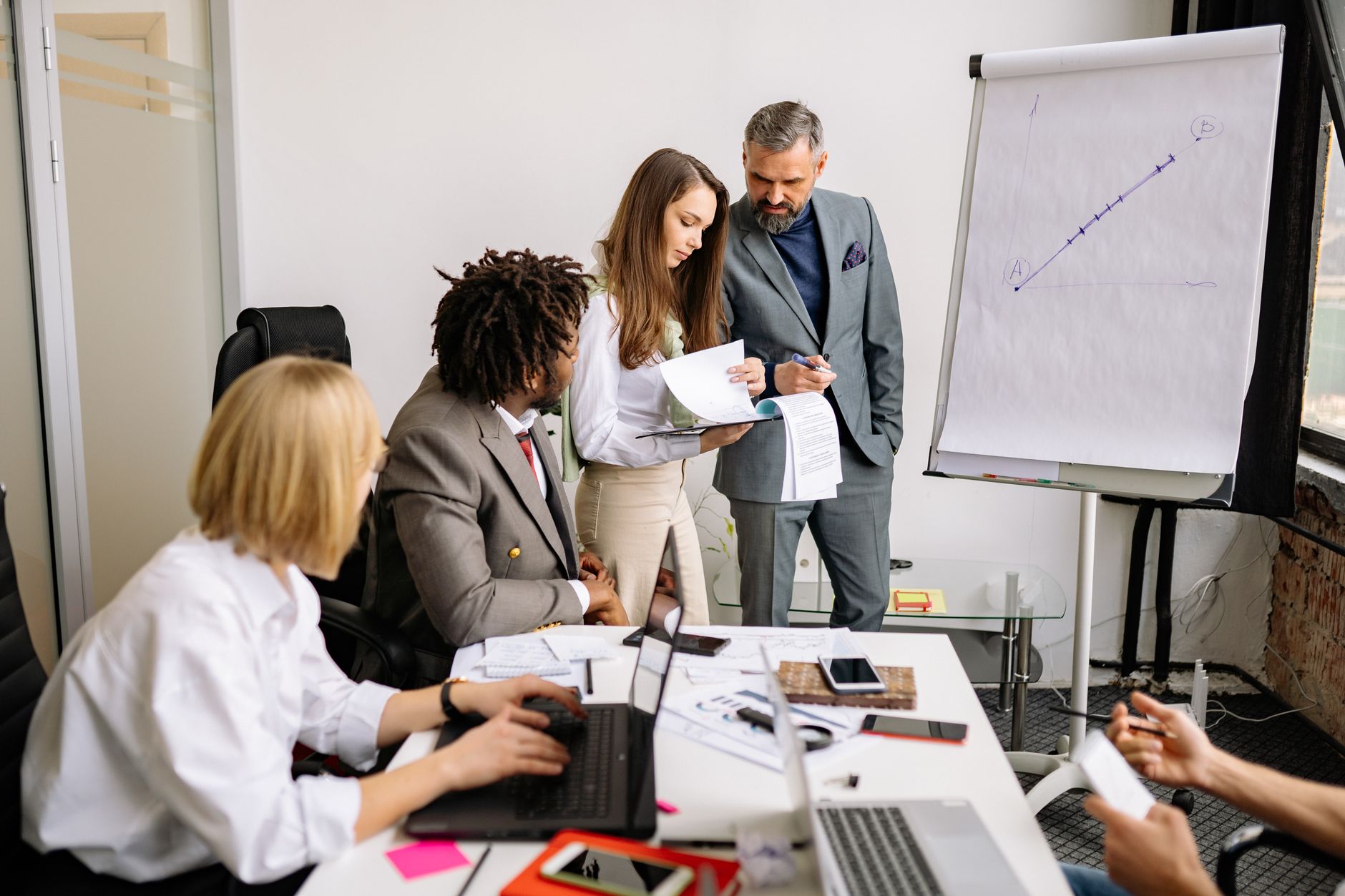 Sales team in a weekly pipeline review meeting around a conference table