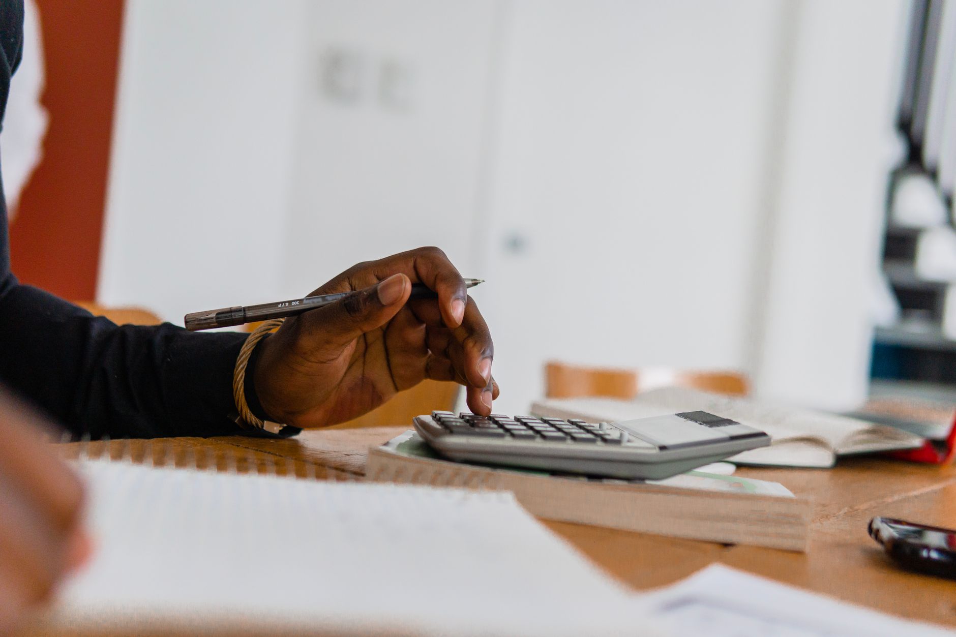 Business owner calculating CRM total cost of ownership on a laptop